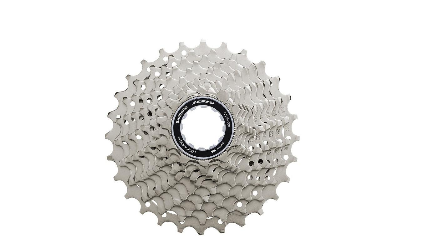 A silver metallic bicycle cassette with multiple sprockets and a black center hub, isolated on a white background.