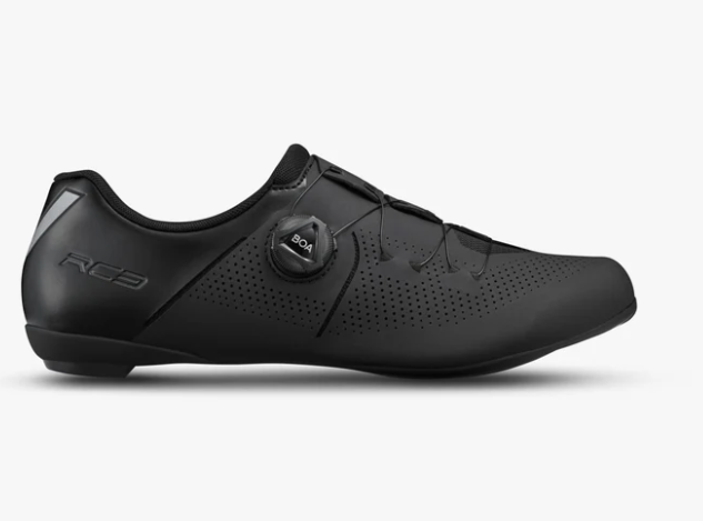 A black shimano cycling shoe with a dial closure system and perforated side panels, shown in profile against a light gray background.