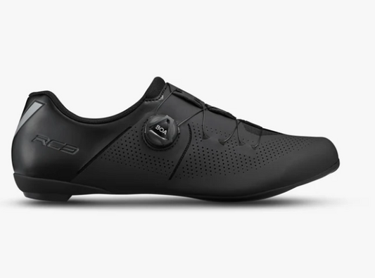 A black shimano cycling shoe with a dial closure system and perforated side panels, shown in profile against a light gray background.